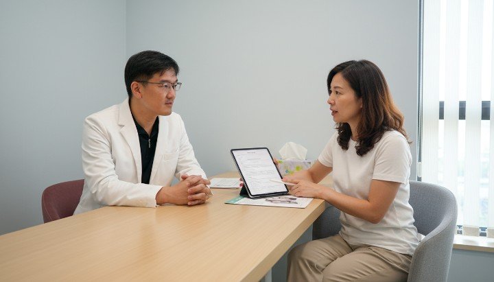 醫師於診間詳細解說醫學美容同意書內容 消費者仔細審閱醫學美容同意書保障權益 專業醫師與患者溝通醫學美容同意書細節 包含療程風險項目的醫學美容同意書範本 確保醫療安全必簽署的醫學美容同意書